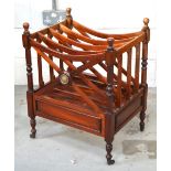 An Edwardian mahogany Canterbury raised on turned supports and brass castors, width 48cm.