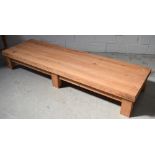 A long low rectangular pitch pine table on block supports, 220 x 65cm.