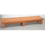 A pitch pine long low rectangular table/bench on block supports, 204 x 45cm.