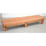 A long low rectangular pitch pine table on block supports, 199 x 55cm.