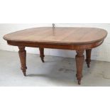A Victorian oak wind-out oval dining table on turned baluster supports and castors,