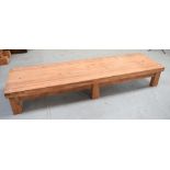 A pitch pine long low rectangular table on block supports, 246 x 69cm.