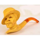 A cased pipe modelled as a man wearing a hat with amber coloured mouthpiece.