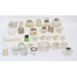 A collection of various predominantly clear glass inkwells,