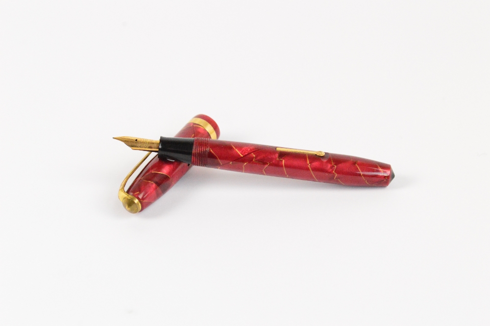 A Conway Stewart 84 fountain pen in gold veined rose coloured body with gold plated trim, length 11.