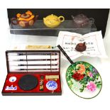 An Oriental collector's lot comprising three boxed Yixin purple clay teapots, a boxed clay tea-toy,