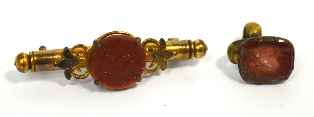 A Victorian yellow metal 'Goldstone' nanny brooch and a carved seal set with a red stone (2).