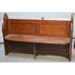 A pitch pine church pew of traditional form with panelled back, length 147cm.
