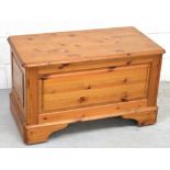 A pine blanket box with hinged top on plinth base,