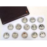 A cased collection of thirteen silver commemorative coins,