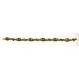 A yellow metal micro mosaic bracelet of six marquise-shape links, with varicoloured tesserae.