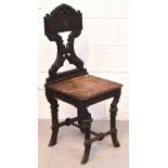 A 19th century shield back cast iron framed hall chair with oak seat.