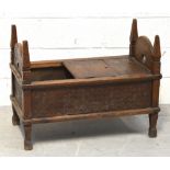 A 19th century oak child's safe bed, probably of Eastern origin with three hinged panels,