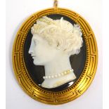 A Victorian yellow metal framed carved agate cameo brooch, the border with geometric design.