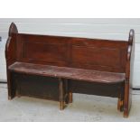 A stained pitch pine church pew of traditional form with panelled back, length 149cm.