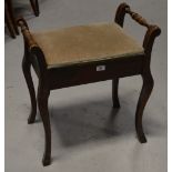 An Edwardian stained piano stool with upholstered lift-up seat.