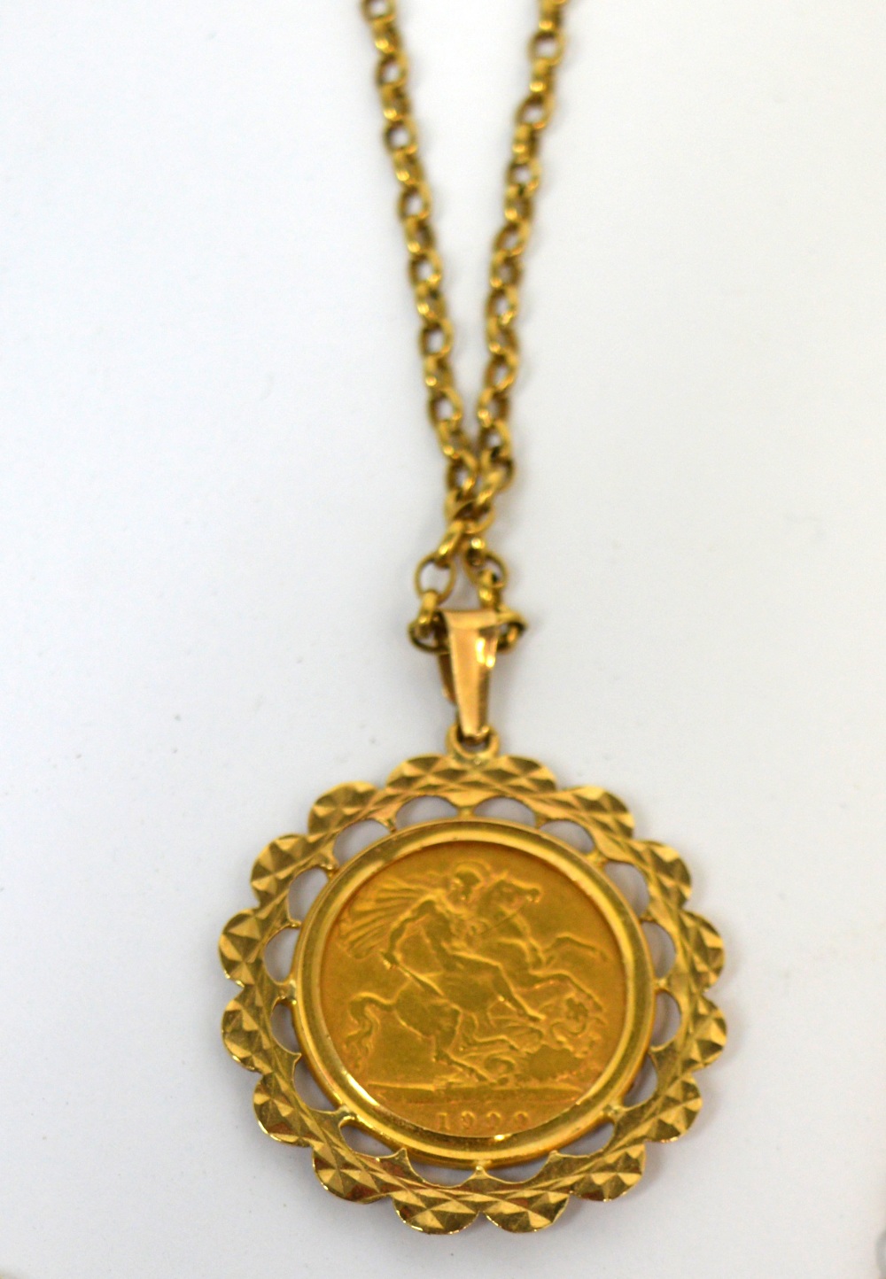 A Victorian half sovereign, 1900, within yellow metal mount, suspended on long 9ct gold chain,