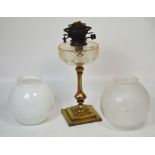 A Victorian brass oil lamp with clear glass font, height 41cm and two shades (3).