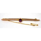 A 9ct yellow gold brooch set with central amethyst-coloured stone.