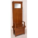 A 20th century oak mirror back hall stand with hinged lift-up seat, width 57cm.