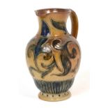 Arthur Barlow for Doulton Lambeth; a stoneware pitcher with stylised floral sgraffito decoration,