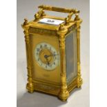 A gilt metal carriage clock inscribed below dial 'E.