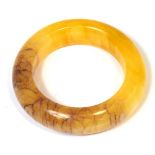 A Tibetan yellow and red jade bangle, diameter 10cm.