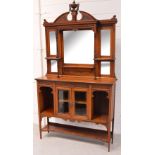 An early 20th century walnut display cabinet, urn carved pediment above four bevel edge plates,