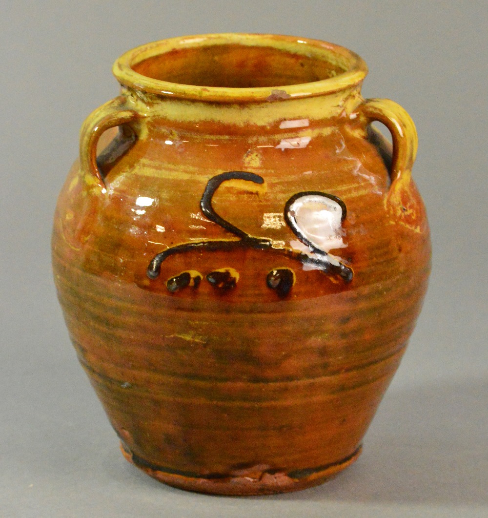 Winchcombe Pottery: an early slipware vase with three lug handles covered in a rich treacle yellow