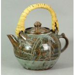 BAWA USHAFA for Abuja Pottery; a stoneware teapot with rush handle covered in kaki,