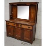 An oak Arts and Crafts inlaid sideboard with a mirrored and panelled upstand above a base of two