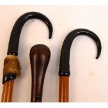 Two goat horn handled walking sticks, both inscribed "Interlaken" and a plain walking cane (3).