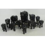 A collection of figures of elephants in various sizes, predominantly with ivory inset tusks,