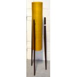 A retro rocket lamp with yellow shade, raised on three tapering wooden supports, height 113cm.