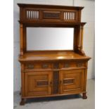 An Edwardian oak mirror back sideboard with carved and pierced top rail,