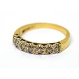 A 9ct yellow gold ring set with a row of illusion set diamonds, size L, approx 2.1g.