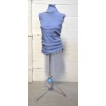 A dressmaker's model with wire body, increment chart and raised on metal tripod support.