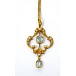 An Edwardian 15ct yellow gold drop pendant set with two aquamarine stones and split seed pearls on