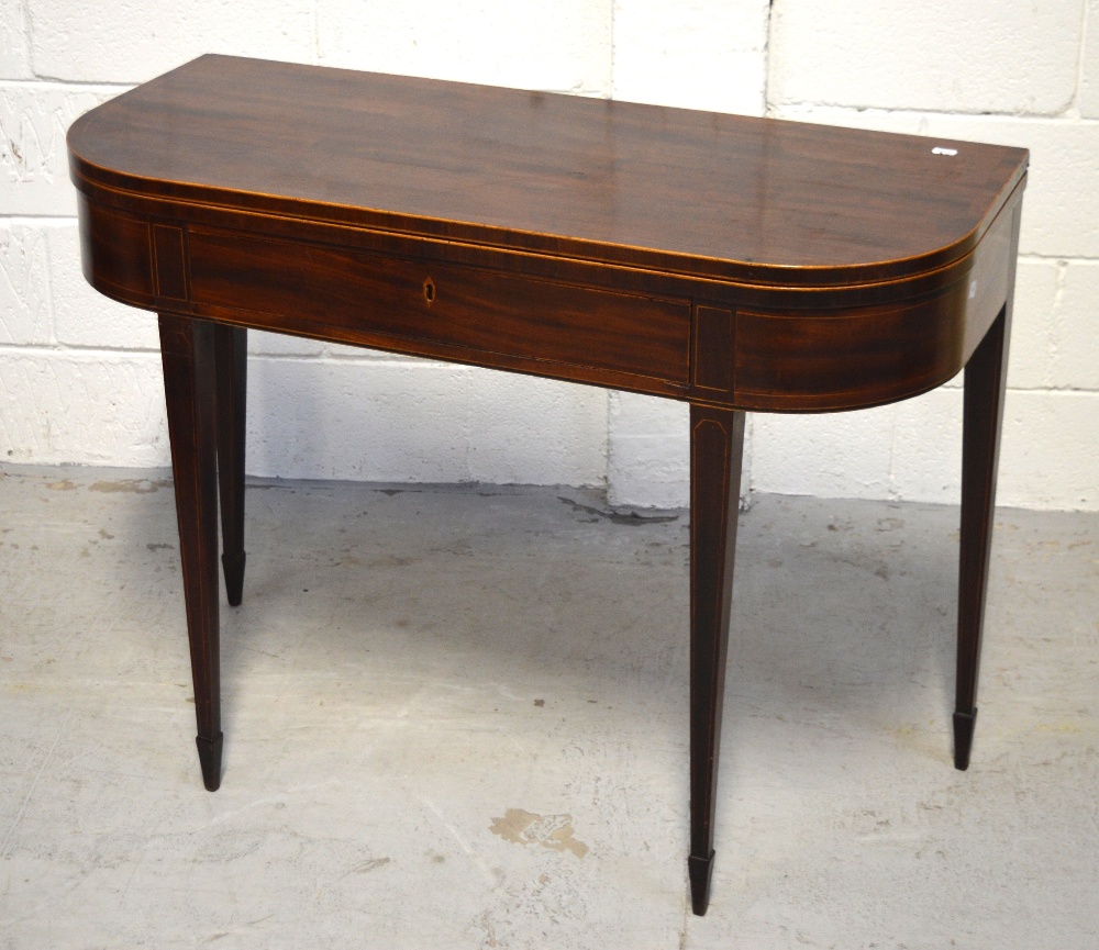 A 19th century mahogany inlaid fold-over card table on tapering supports and peg feet,