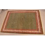 An Indian hand-knotted green ground rug, 255 x 170cm.