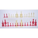 A set of early 20th century carved bone chess pieces, natural and red dyed.