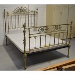 An Edwardian brass bed, with carved curved back rail with filigree work,
