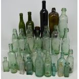 A collection of approximately thirty early 20th century glass bottles,