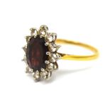 An 18ct yellow gold ruby coloured stone and twelve stone diamond floral set ring, size P, approx 4g.