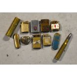 Eleven various military-related lighters to include one example modelled as a shell case,