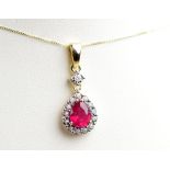 A 9ct yellow gold ruby and diamond pendant suspended on a fine link chain,