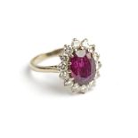**AMENDED DESCRIPTION** An 18ct white gold cluster ring set with an oval cut purple coloured stone
