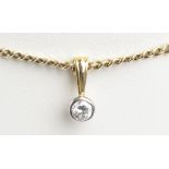 A 9ct yellow gold flat link chain supporting a bezel set single stone diamond pendant weighing