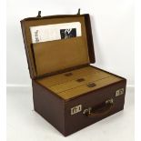 A rectangular leather case revealing three graduated drawers and with top carrying handle,