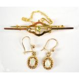 An Edwardian 9ct yellow gold bar brooch with lobed central sections set with peridot flanked by two